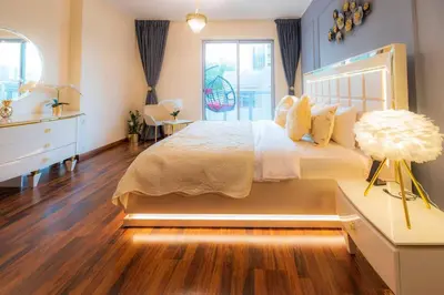 a bedroom with a bed and a dresser and a window at FIRST CLASS 2BR with full BURJ KHALIFA and FOUNTAIN VIEW in Dubai