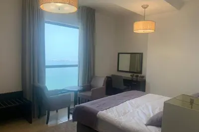a bedroom with a bed and a desk and a window at Beautiful apartment with amazing sea views in Dubai