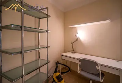 a room with a desk with a lamp and a shelf at New Arabian Trident Waterfront 3 BR plus maid in Dubai