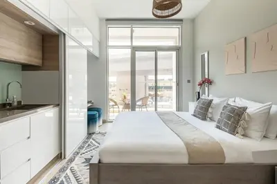 a bedroom with a large bed and a kitchen at Frank Porter - Studio One in Dubai