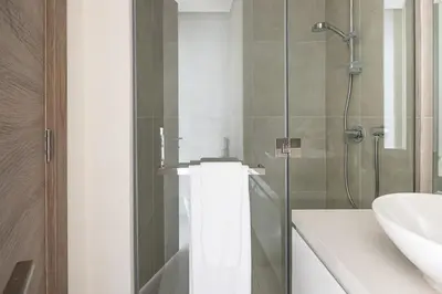 a bathroom with a glass shower and a sink at Frank Porter - Studio One in Dubai