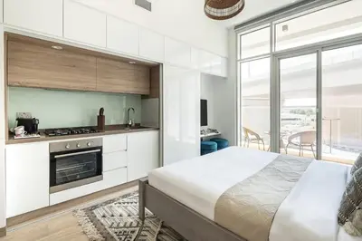 a white kitchen with a bed in a room at Frank Porter - Studio One in Dubai