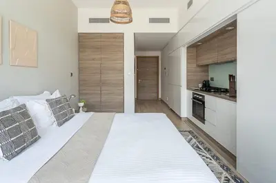 a large white bed in a room with a kitchen at Frank Porter - Studio One in Dubai