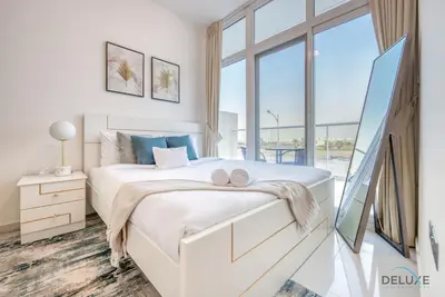 a bedroom with a white bed with a large window at Delightful 3BR Townhouse at DAMAC Hills 2 Dubailand by Deluxe Holiday Homes in Dubai
