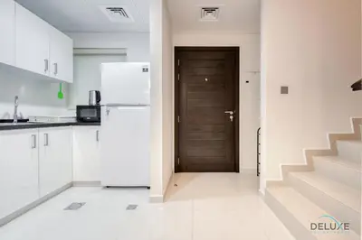 a kitchen with a white refrigerator and a door at Delightful 3BR Townhouse at DAMAC Hills 2 Dubailand by Deluxe Holiday Homes in Dubai