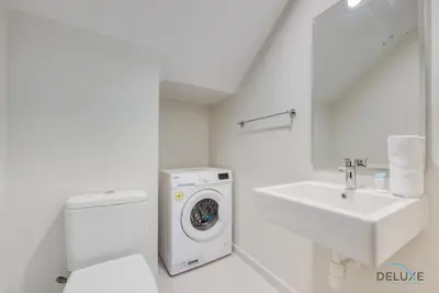 a white bathroom with a washing machine and a sink at Opulent 3BR Townhouse at DAMAC Hills 2 Dubailand by Deluxe Holiday Homes in Dubai