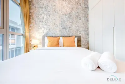 a bedroom with a large white bed with orange pillows at Opulent 3BR Townhouse at DAMAC Hills 2 Dubailand by Deluxe Holiday Homes in Dubai