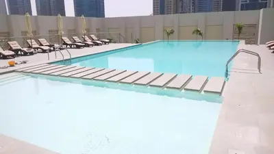 a large swimming pool with lounge chairs on a building at 1 BD in West Avenue tower Dubai Marina in Dubai
