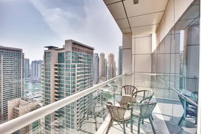a balcony with chairs and a view of the city at 1 BD in West Avenue tower Dubai Marina in Dubai