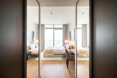 a bedroom with a bed and a mirror at Luton Vacation Homes - Marina View & Luxury 1BR - Jumeirah Living Marina Gate Tower 3 - 54AB49AB36AB in Dubai