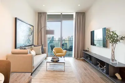 a living room with a couch and a tv at Luton Vacation Homes - Marina View & Luxury 1BR - Jumeirah Living Marina Gate Tower 3 - 54AB49AB36AB in Dubai