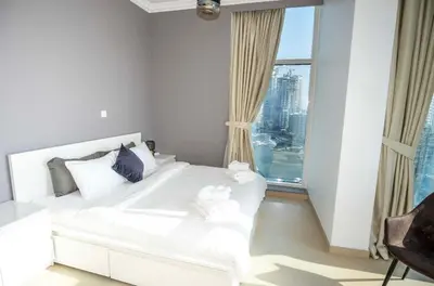 a white bed in a room with a large window at WSuites - Big Terrace with Beautiful Marina View in Dubai