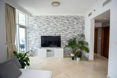 a living room with a tv and a brick wall at WSuites - Big Terrace with Beautiful Marina View in Dubai