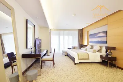 a hotel room with a bed and a desk at New Arabian -Address Emaar Fashion Avenue in Dubai