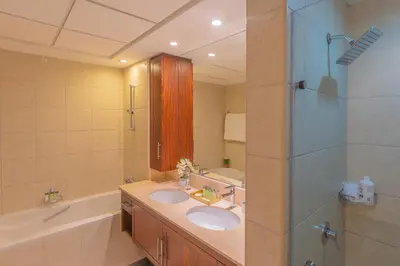 a bathroom with two sinks and a bath tub at Spectacular Burj & Fountain View - Luxurious 3 Bedrooms & Maids room - The Residences in Dubai