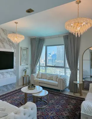 a living room with a couch and a tv at Spectacular Burj & Fountain View - Luxurious 3 Bedrooms & Maids room - The Residences in Dubai