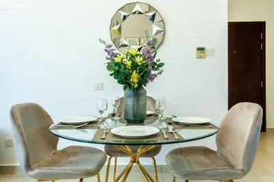 a table with chairs and a vase of flowers on it at bnbmehomes - La Fontana in Dubai