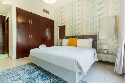 a bedroom with a large white bed and wooden cabinets at bnbmehomes - La Fontana in Dubai