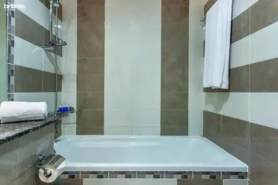 a bathroom with a tub and a shower with towels at bnbmehomes - La Fontana in Dubai