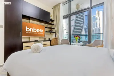 a hotel room with a bed and a large window at bnbmehomes - Merano Tower in Dubai