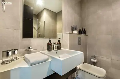 a white bathroom with a sink and a toilet at bnbmehomes - Merano Tower in Dubai