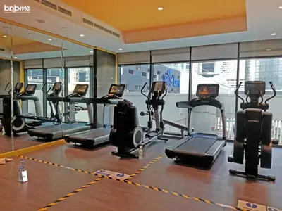 a gym with treadmills and ellipticals in a building at bnbmehomes - Merano Tower in Dubai