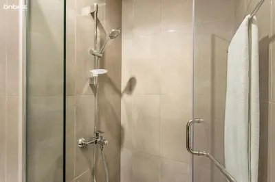 a shower with a glass door in a bathroom at bnbmehomes - Merano Tower in Dubai