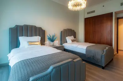a bedroom with two beds and a chandelier at FIRST CLASS 3BR with full BURJ KHALIFA and FOUNTAIN VIEW in Dubai