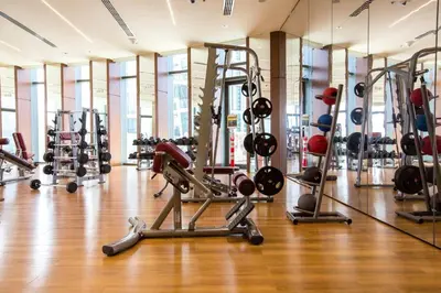 a gym with several treadmills and weights at FIRST CLASS 3BR with full BURJ KHALIFA and FOUNTAIN VIEW in Dubai