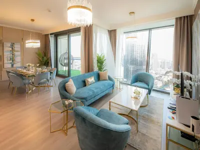 a living room with blue furniture and a dining room at FIRST CLASS 3BR with full BURJ KHALIFA and FOUNTAIN VIEW in Dubai
