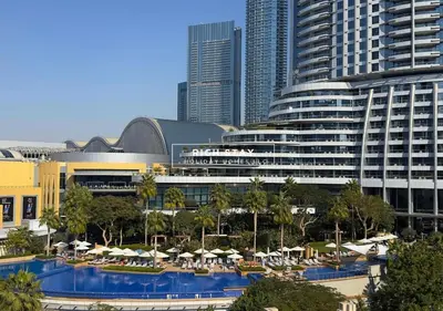 a resort with a pool with umbrellas and a large building at Spectacular 2BR in Souk Al Bahar, Downtown with Burj & Dubai Mall view by Rich Stay in Dubai
