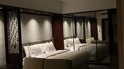 a bedroom with two beds and a large mirror at SITARA HOTEL APARTMENT in Dubai