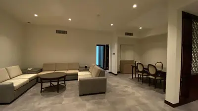 a living room with a couch and a table and chairs at SITARA HOTEL APARTMENT in Dubai