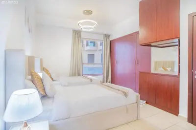 a bedroom with a white bed and a window at Gardenia Rimal Suites, Luxury Apartments in JBR with 2 min Walk to JBR beach in Dubai
