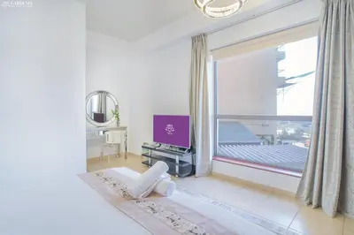 a white room with a large window and a television at Gardenia Rimal Suites, Luxury Apartments in JBR with 2 min Walk to JBR beach in Dubai