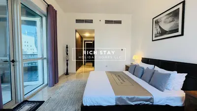 a bedroom with a king sized bed and a window at Canal View 2BR & Maid Room in KG Tower, Dubai Marina in Dubai