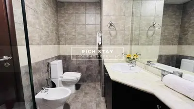a bathroom with a toilet and a sink at Canal View 2BR & Maid Room in KG Tower, Dubai Marina in Dubai