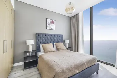 a bedroom with a large bed and a large window at EDEN'S Homes & Villas - 52-42 Emaar in Dubai
