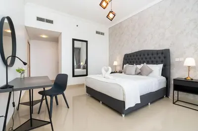 a bedroom with a bed and a desk and a table at White Sage - Incredible Full Sea and Dubai Eye View in Marina in Dubai