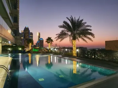 a swimming pool with a palm tree and a city skyline at White Sage - Incredible Full Sea and Dubai Eye View in Marina in Dubai