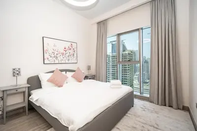 a bedroom with a bed and a large window at Tranquil Retreat with Canal View 1BR MBL Residence - 29AB12 in Dubai