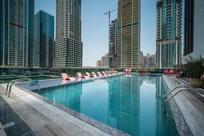a large swimming pool in a city with tall buildings at Tranquil Retreat with Canal View 1BR MBL Residence - 29AB12 in Dubai