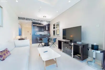 a living room with a white couch and a tv at Downtown Damac Distinction Full Burj View in Dubai