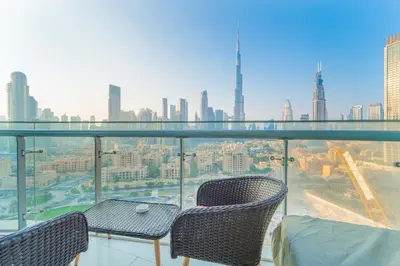 a balcony with two chairs and a view of a city at Downtown Damac Distinction Full Burj View in Dubai