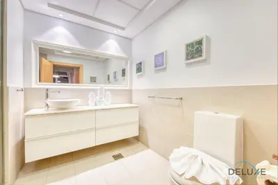 a white bathroom with a sink and a mirror at Lively 1 BR at Al Nabat Shoreline 8 Palm Jumeirah by Deluxe Holiday Homes in Dubai