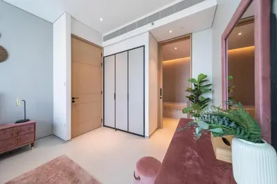 a hallway with a pivot door and a table with a plant at EDEN'S Homes & Villas - ADDRESS BEACH Residences JBR in Dubai