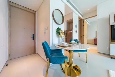 a dining room with a table and chairs and a mirror at EDEN'S Homes & Villas - ADDRESS BEACH Residences JBR in Dubai