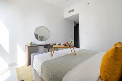 a bedroom with a bed with a table and a mirror at Frank Porter - Creekside18 in Dubai