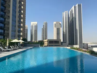 a large swimming pool in a city with tall buildings at Frank Porter - Creekside18 in Dubai