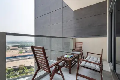 two chairs and a table on a balcony with a view at EDEN'S Homes & Villas - Atria Residences in Dubai